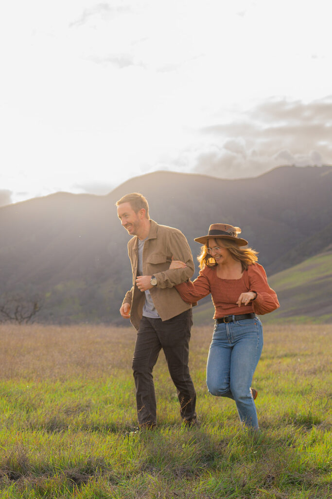 Couple running together with mountains in the background in Clayton, California